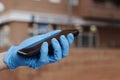 Man wearing latex gloves using his smartphone Royalty Free Stock Photo