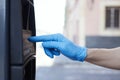 Man wearing latex gloves using a parking meter Royalty Free Stock Photo