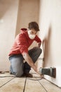 Man Wearing Mask While Sanding Wall