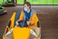 Man wearing a medical mask during COVID-19 coronavirus having a ride in the bumper car at the amusement park