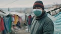 A man wearing a medical protective mask on his face. A volunteer in a refugee camp
