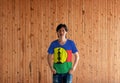 Man wearing New Caledonia flag color shirt and standing with two hands in pant pockets on the wooden wall background Royalty Free Stock Photo