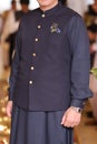 Man wearing Pakistani traditional dress shalwar kameez and waistcoat with golden buttons and pocket