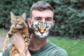 Man wearing protective mask with print of his catÃÂ´s face
