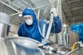 Man wearing protective suit and mask opening tank at chemical plant or factory Royalty Free Stock Photo