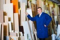 Man wearing protective workwear standing with plywood in store Royalty Free Stock Photo