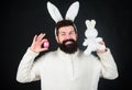Man wearing rabbit suit. Funny bunny man with easter egg and toy. Easter activities concept. Egg hunt game. Guy bearded