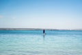 Man wearing rash guard on a stand-up paddle board at the ocean bay in Australia. SUP water sport activity Royalty Free Stock Photo