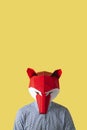 Man wearing a red fox mask on a yellow background Royalty Free Stock Photo