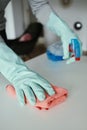 Man wearing rubber gloves cleaning a table indoors