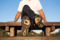 A man wearing running shoes with worn-out outsole is sitting on a bench table Royalty Free Stock Photo