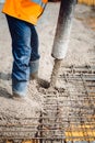 man wearing safety equipment using cement pump and pouring concrete slab Royalty Free Stock Photo