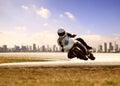 Man wearing safety suit riding sport racing motorcycle on sharp curve highway