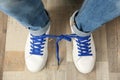 Man wearing sneakers with tied laces, top view. April fool`s day