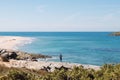 Man wearing sports clothes and carrying a backpack takes pictures of the Atlantic coastline near Porto Covo, Portugal. Capturing Royalty Free Stock Photo