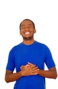 Man wearing strong blue t-shirt standing and laughing hard holding his stomach, white studio background