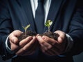 A man wearing a suit is holding a small sapling in his hands