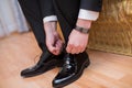 Closeup view of male hands lacing beautiful elegant shoes. wedding day. groom tie his shoe . Man wearing a suit putting his brown Royalty Free Stock Photo