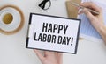 a man wearing a suit showing a signboard with the text happy labor day written Royalty Free Stock Photo