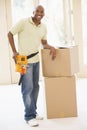 Man wearing tool belt by boxes in new home Royalty Free Stock Photo