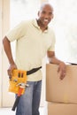 Man wearing tool belt by boxes in new home Royalty Free Stock Photo