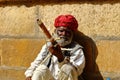 A man wearing turban is siting on ground and playing vilolin at Jaiselmer Rajasthan India Royalty Free Stock Photo