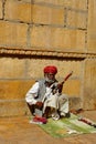 A man wearing turban is siting on ground and playing vilolin at Jaiselmer Rajasthan India Royalty Free Stock Photo
