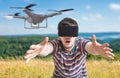 Man wearing virtual reality headset is controlling a flying drone