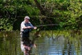 A Man Fly Fishing on a River.