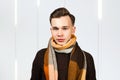 Man wearing warm winter coat, scarf. Portrait of a handsome young Guy ready for cold winter weather