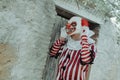 man is putting on a clown mask in front of a house Royalty Free Stock Photo