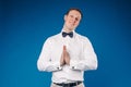 Man wearing white shirt and bow tie showing sign of pistol