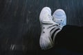 Man wearing white sneakers in black trousers sitting on coffee shop Royalty Free Stock Photo