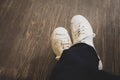 Man wearing white sneakers in black trousers sitting on coffee shop Royalty Free Stock Photo