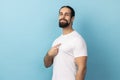 Man wearing white T-shirt pointing at himself, feeling proud and self-important, having big ego. Royalty Free Stock Photo