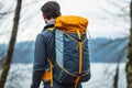 A Man Wearing a Yellow and Blue Backpack in a Forest Setting Royalty Free Stock Photo
