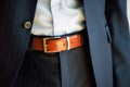 Man wears belt. Young businessman in casual suit with accessories. Fashion and clothing concept. Groom getting ready in