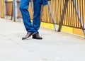Man wears blue trousers with brown shoes