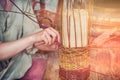 A man weaves a basket of willow branches. Master basketmaker creates at work in the Studio