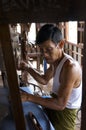 Man weaving silk by hand on a machine