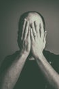 Man with a wedding ring covering his face with his hands Royalty Free Stock Photo