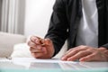 Man with wedding ring and divorce papers at table indoors, closeup. Space for text Royalty Free Stock Photo