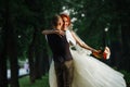 Man after wedding spinning with wife in his hands in the dark alley Royalty Free Stock Photo