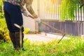 Man weeding his garden with hoe.