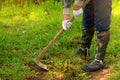 Man weeding his garden with hoe.