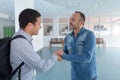 man welcoming young visitor with warm handshake Royalty Free Stock Photo