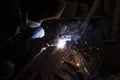 Man welder cooks metal. Sparks from the welding machine