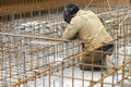 Man welder is welding metal frame for concrete foundation of the building. Royalty Free Stock Photo