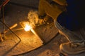 A man welds together a makeshift trowel, putty knife or scraper from two pieces of metal. Royalty Free Stock Photo