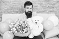 Man well groomed wear tuxedo bow tie hold flowers tulips bouquet and big teddy bear toy. Invite her dating. Romantic